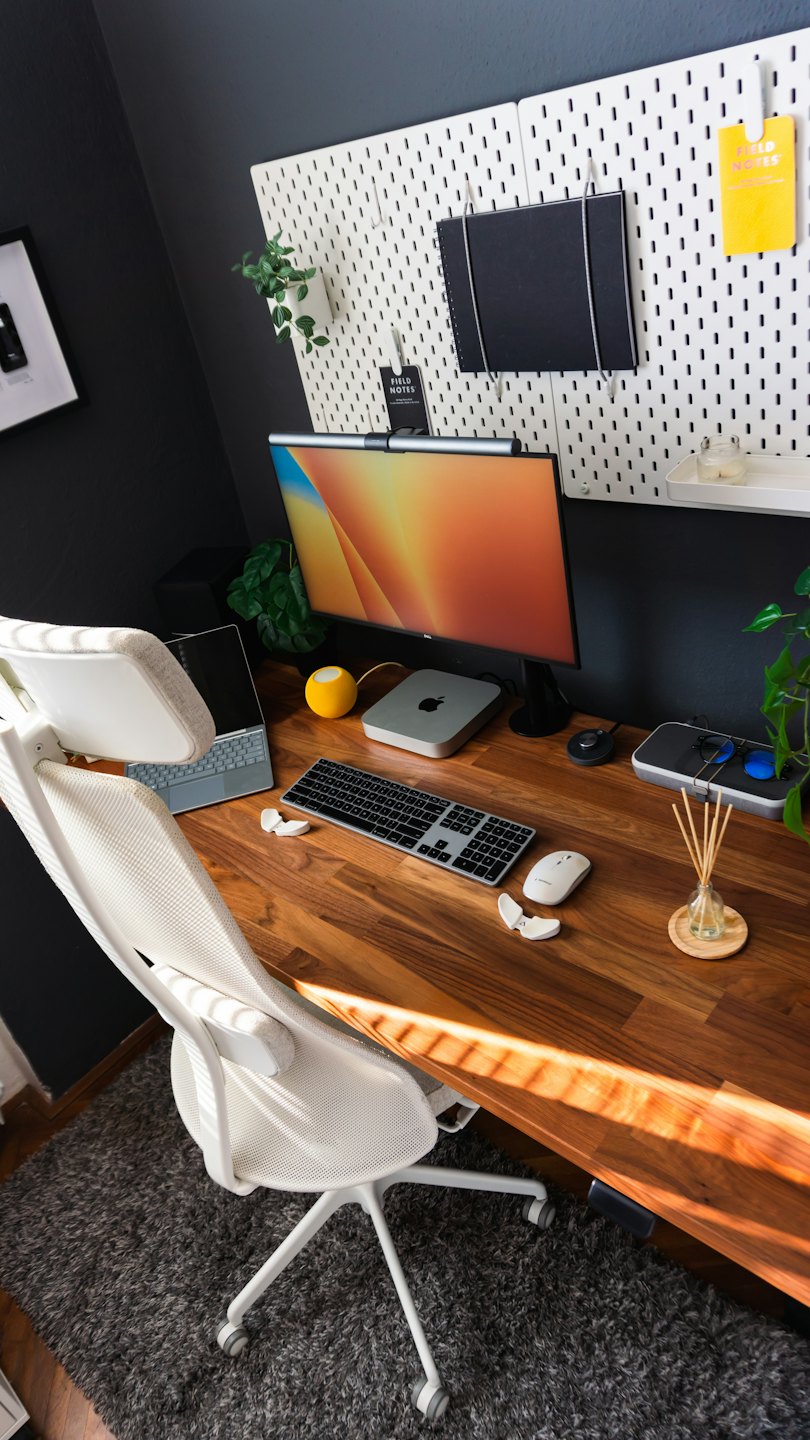 Modern home office desk with computer equipment and organizational wall accessories.